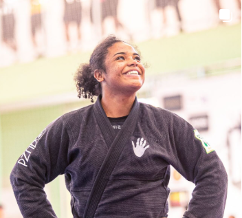 Atleta sorrindo com kimono em ambiente de treino