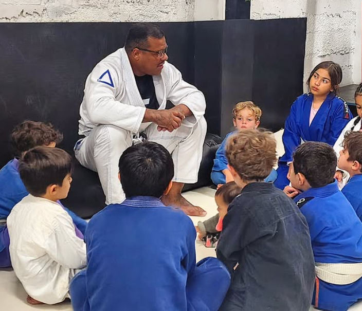 Rodrigo Tiburcio conversando com crianças no tatame