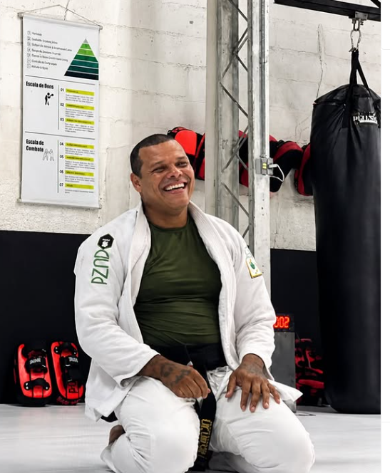 Rodrigo Tiburcio sorrindo sentado no tatame
